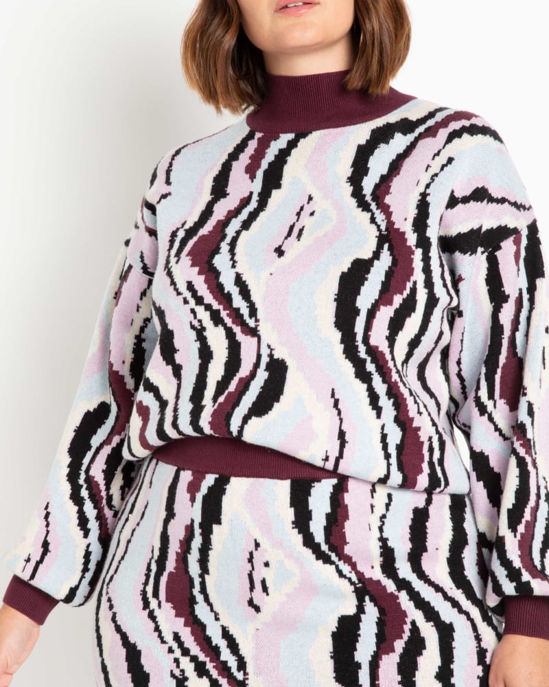 Front of a model wearing a size 14/16 Intarsia Checkerboard Sweater in Hold the Lines by ELOQUII. | dia_product_style_image_id:236335